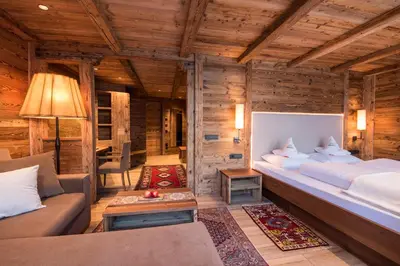 a bedroom with a large bed in a log cabin at Charmehotel Uhrerhof - Deur in Ortisei
