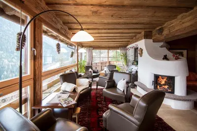a waiting room with chairs and a fireplace at Charmehotel Uhrerhof - Deur in Ortisei