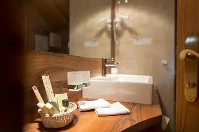 a bathroom with a sink and a counter with towels at Charmehotel Uhrerhof - Deur in Ortisei