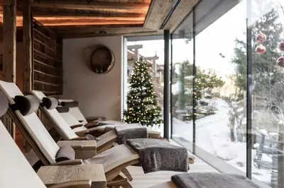 a room with a christmas tree and a group of chairs at Charmehotel Uhrerhof - Deur in Ortisei