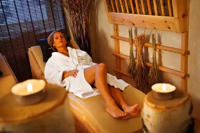 a woman sitting on a chair in a room at Naturhotel Sonnenhof in Chiusa