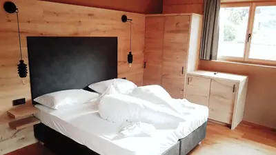 a bedroom with a bed with white sheets and pillows at Naturhotel Sonnenhof in Chiusa