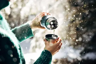 a person pouring water from a camera into a cup at Naturhotel Sonnenhof in Chiusa