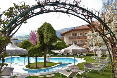 an archway over a swimming pool at a resort at Naturhotel Sonnenhof in Chiusa
