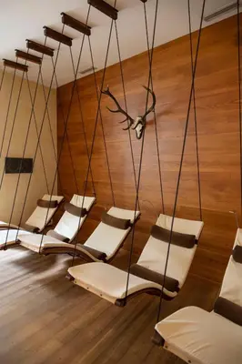 a group of chairs in a room with wooden floors at Artnatur Dolomites Hotel & Spa in Siusi