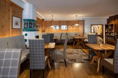 a dining room with wooden tables and chairs at Artnatur Dolomites Hotel & Spa in Siusi