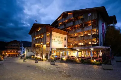 a large building with lights in front of it at Artnatur Dolomites Hotel & Spa in Siusi