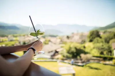 a woman holding a wine glass with a view at Hotel Torgglhof in Caldaro