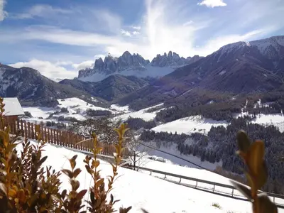 a train traveling through a snow covered mountain range at Ritzhof in Funes