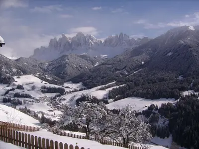 a view of a snowy mountain range with a fence at Ritzhof in Funes