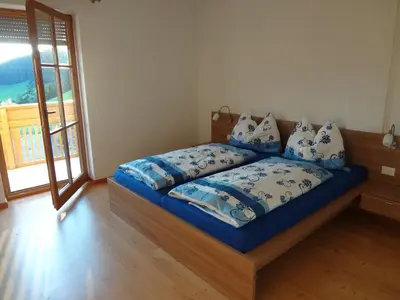 a bedroom with a bed with blue comforter and pillows at Ritzhof in Funes