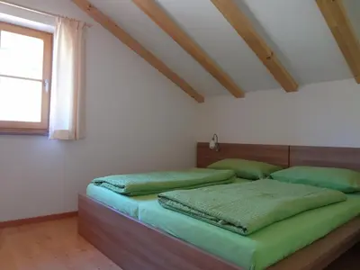 a bedroom with two beds with green sheets and a window at Ritzhof in Funes