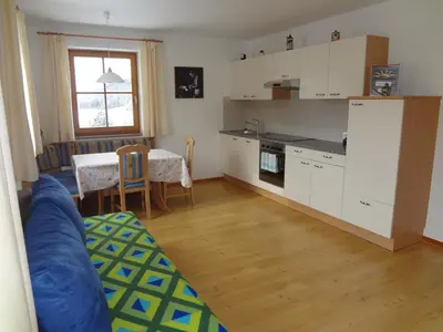 a kitchen with a couch and a table in a room at Ritzhof in Funes