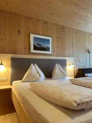 a bedroom with a large bed with two pillows at Liebharterhof in Valdaora