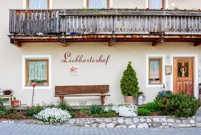 a building with a balcony and a bench at Liebharterhof in Valdaora