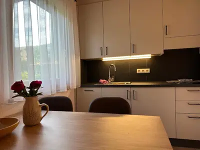 a kitchen with a table with a vase of flowers on it at Liebharterhof in Valdaora