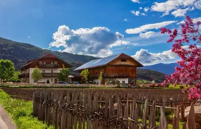 a barn and a house with a fence at Liebharterhof in Valdaora