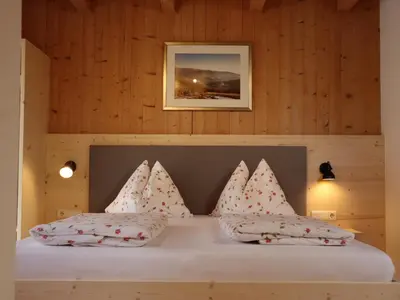 a bedroom with a white bed with red pillows at Liebharterhof in Valdaora