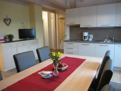 a kitchen with a table with a vase of flowers on it at Liebharterhof in Valdaora