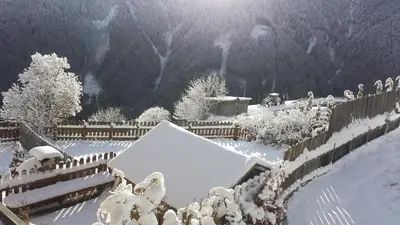 a yard covered in snow with a fence at Pension Schönblick in Campo di Trens