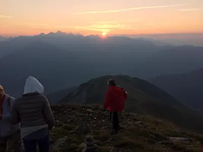 a group of people standing on a mountain watching the sunset at Pension Schönblick in Campo di Trens