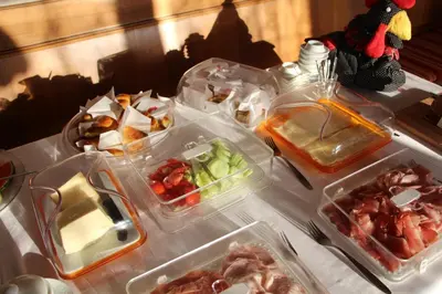 a table topped with plastic containers filled with food at Pension Schönblick in Campo di Trens