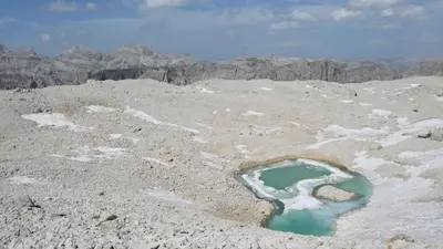 a pool of water in the middle of a mountain at Hotel Garni Ruscel in Santa Cristina in Val Gardena