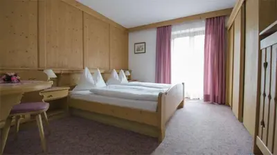 a hotel room with a bed and a window at Hotel Garni Ruscel in Santa Cristina in Val Gardena