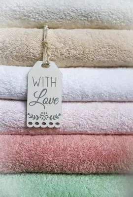a pile of towels with a sign that reads with love at Apartments Vaiolet in Santa Cristina in Val Gardena