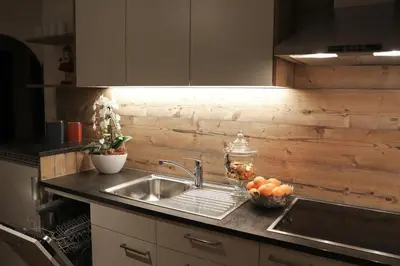 a kitchen counter with a sink and a bowl of fruit at Apartments Vaiolet in Santa Cristina in Val Gardena