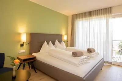 a bedroom with a large white bed with a window at Brühl Suites&Residence in Caldaro