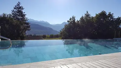 a swimming pool with mountains in the background at Brühl Suites&Residence in Caldaro