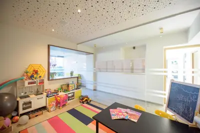 a childs room with a table and a large window at Brühl Suites&Residence in Caldaro
