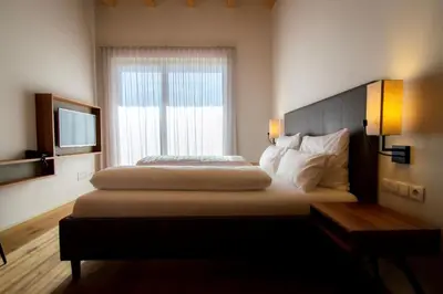 a hotel room with two beds and a window at Brühl Suites&Residence in Caldaro