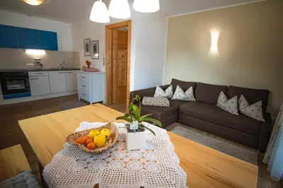 a living room with a table with a bowl of fruit on it at Apartment CANUS - Krumas Living - Kronplatz in San Lorenzo di Sebato