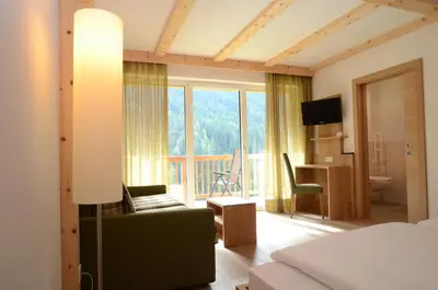a hotel room with a bed and a view of a balcony at Gasthof Edelweiss in Tires