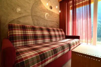 a plaid couch in a room with a window at Gasthof Edelweiss in Tires