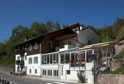 a large white building with windows on a street at Gasthof Edelweiss in Tires