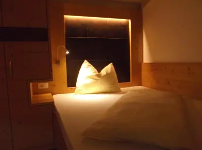 a bed with a pillow in a room with a window at Gasthof Edelweiss in Tires
