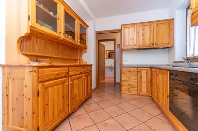 a large kitchen with wooden cabinets and a tile floor at Villa Eden in Falcade
