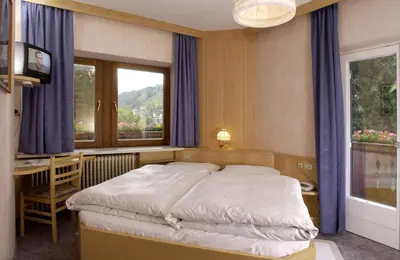 a bathroom with a sink and a mirror and a toilet at Garni-Hotel Pichler in Ortisei