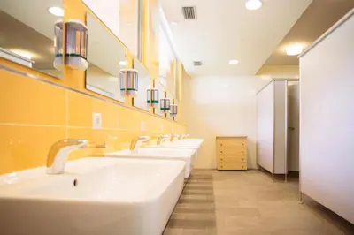 a bathroom with four sinks and a row of mirrors at Camping Zögghof in San Leonardo in Passiria