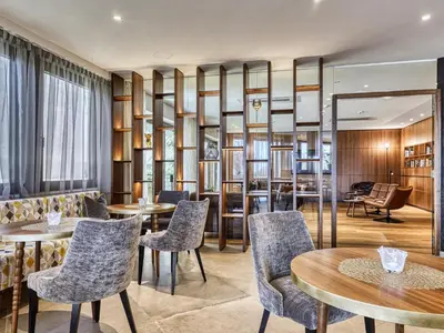 a restaurant with tables and chairs in a room at Hotel Traubenheim in Tirolo