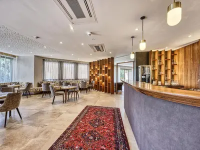 a restaurant with a bar with tables and chairs at Hotel Traubenheim in Tirolo