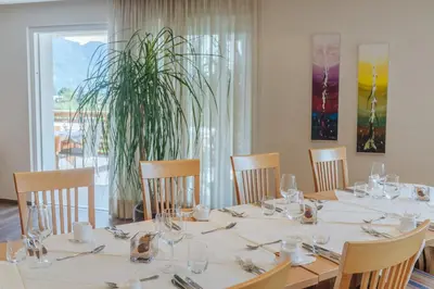 a dining room with a table with chairs and a plant at Hotel Elisabeth in Merano