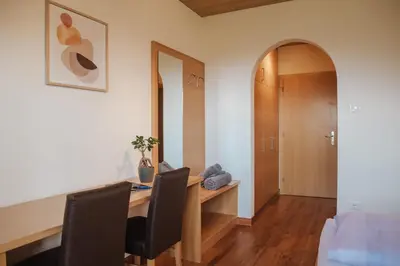 a room with a desk with two chairs and a mirror at Hotel Elisabeth in Merano