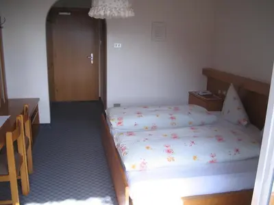 a small bedroom with a bed and a table at Hotel Elisabeth in Merano