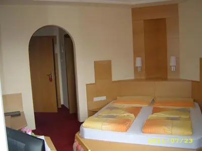 a bedroom with two beds and an open doorway at Hotel Elisabeth in Merano