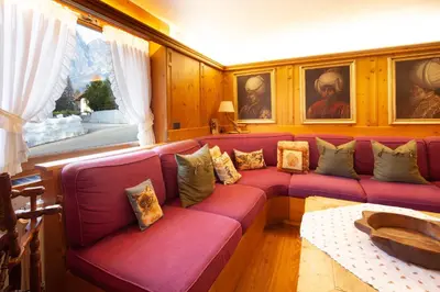 a living room with a red couch with pillows at Casa Marmorata in Cortina dʼAmpezzo
