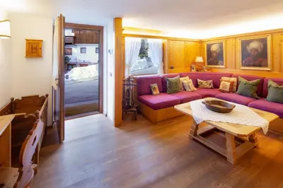 a living room with a purple couch and a table at Casa Marmorata in Cortina dʼAmpezzo